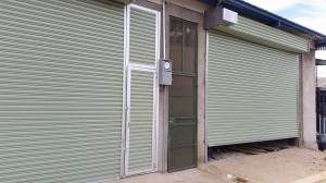 Cortina metálica con puerta del mismo estilo