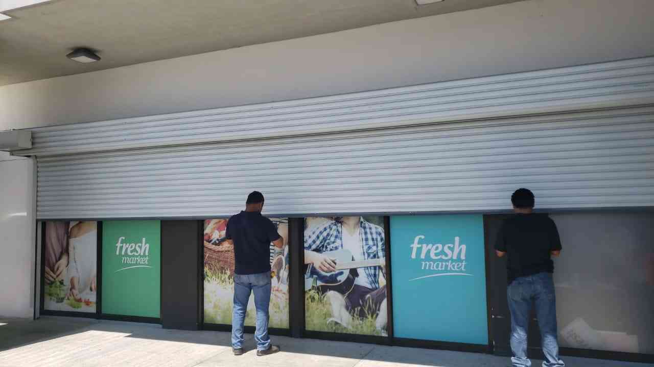 dos personas instalando una cortina metalica