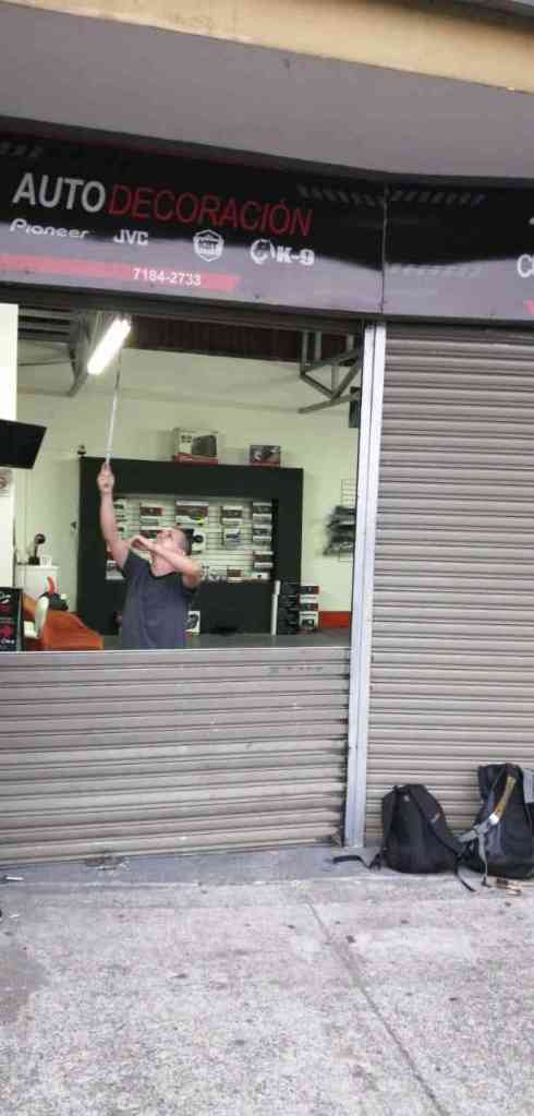 persona joven manipulando cortina metálica con resorte de tensión dañado